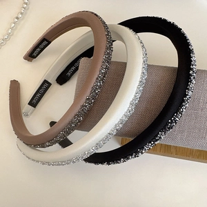 Close-up of three sparkling rhinestone sponge headbands in black, beige and coffee colors