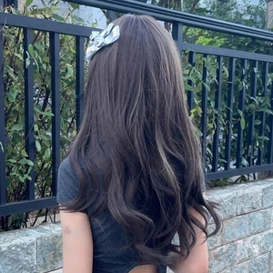 Elegant silver silk bow hair clip on long wavy hair, outdoor natural setting view