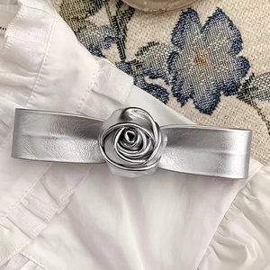 Close-up of a silver 3D rose hair clip with metallic finish on white fabric