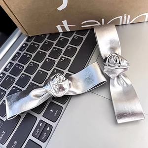 Detailed view of 3D silver rose hair clips with realistic metallic leather texture