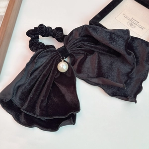 Chouchou élégant en velours noir avec pendentif perle sur fond blanc épuré