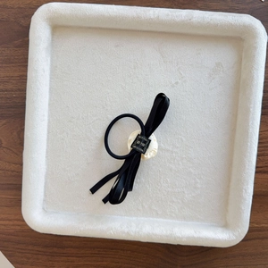 Elegant Korean style black satin ribbon hair tie with white floral bow on jewelry tray