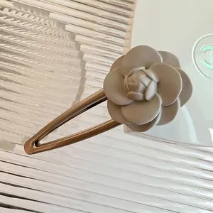 Elegant cream white camellia hair clip with golden metal base for women's hair styling
