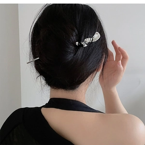 Gros plan d'un pic à cheveux argenté ondulé avec design de lave dans un chignon