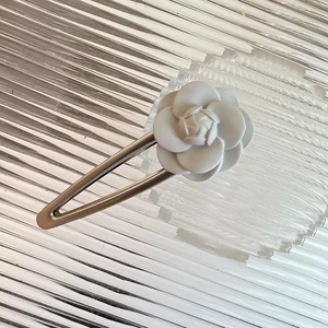 Detail of elegant vintage white camellia flower hair clip with silver metal barrette