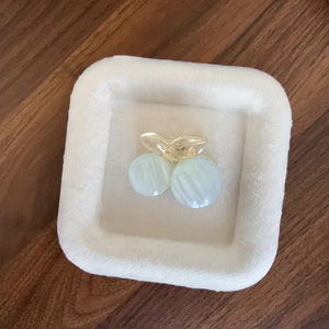 Elegant cherry hair claw clip with blue cat eye stones on a white velvet tray