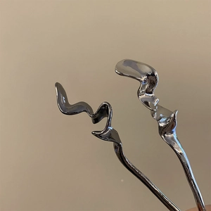 Vue macro détaillée d'épingles à cheveux argentées au design ondulé minimaliste