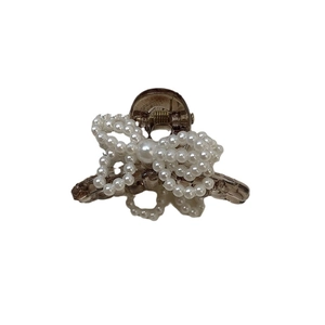 Elegant pearl bow hair claw clip in creamy white and amber resin for women's hairstyle