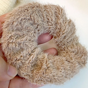 Gros plan d'un chouchou en peluche beige montrant la texture douce de la fausse fourrure
