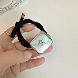 Detail of square silver brushed hair tie with a sparkling star centered on a black elastic