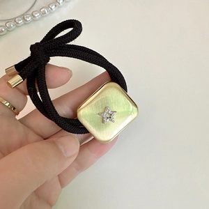 Elastic hair tie with gold brushed square metal charm and sparkling rhinestone star