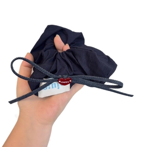Blue pleated scrunchie with denim bow and red heart Happy pendant on model hand