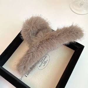 Vue détaillée d'une pince à cheveux en peluche marron café douce pour les femmes