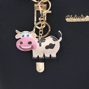 Black litchi grain leather bag with golden keychain hook and cute cartoon cow charm