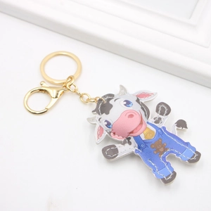 Porte-clés vache en cuir avec salopette bleue et fermoir doré sur fond blanc minimaliste