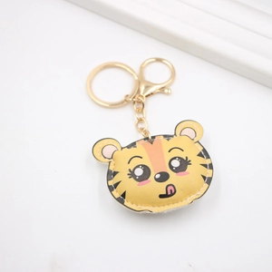 Süßer gelber Tiger-Leder-Schlüsselanhänger mit goldenem Karabinerhaken und Ring auf Weiß