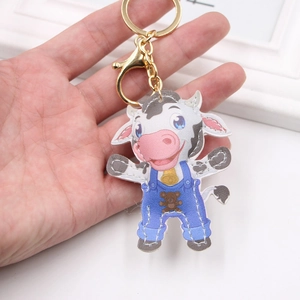 Porte-clés vache en cuir avec salopette bleue et clip doré pour accessoire de sac