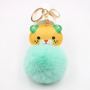 Detail of tiger plush keychain featuring mint green faux fur and gold metal hardware