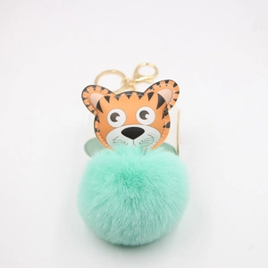 Vue détaillée du porte-clés tigre avec pompon vert menthe et anneau métallique doré