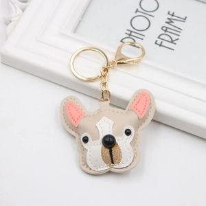 Close-up of beige PU leather French bulldog keychain with golden metal ring and clasp