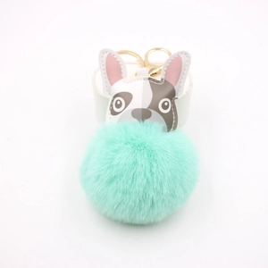 Dettaglio del ciondolo bulldog con pompon in ecopelliccia verde menta e chiusura dorata