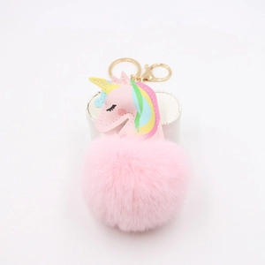 Detailed view of pink plush unicorn keychain with faux fur ball and golden hardware