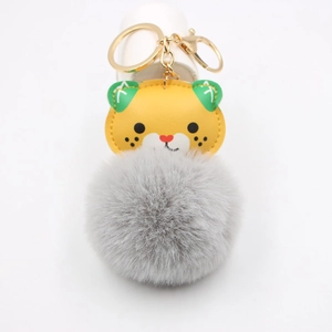 Cartoon tiger plush keychain with orange faux leather and fluffy grey pompom accessory