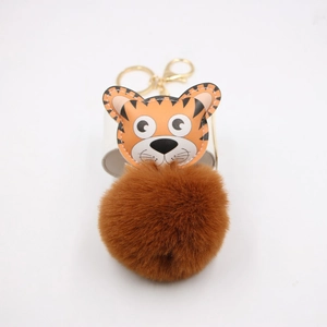 Détail du porte-clés tigre orange avec pompon en fausse fourrure et fermoir doré