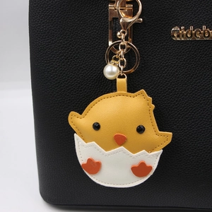 Simpatico portachiavi pulcino in pelle PU gialla con perla su una borsa a mano nera