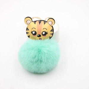 Vue détaillée du porte-clés tigre en cuir avec un grand pompon moelleux de couleur menthe