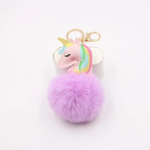Detailed close-up of pink leather unicorn head with purple faux fur pompom keychain