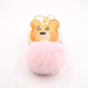 Detail of cute bear plush keychain with pink fur ball and brown leather mascot head