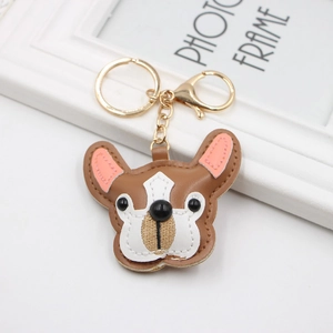 Detailed view of handmade brown and white leather bulldog keychain with gold metal clasp