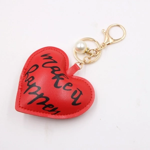 Red heart leather keychain with gold hardware and Make It Happen text for bags