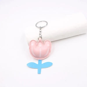 Close-up of pink and blue faux leather tulip keychain with detailed white stitching