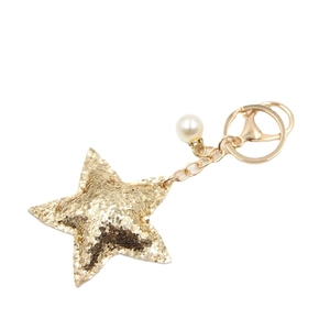 Glittering gold star keychain with faux pearl charm and lobster clasp on white background