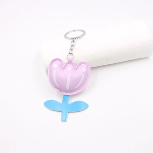 Close-up of pink tulip leather keychain with blue stem and precise stitching details
