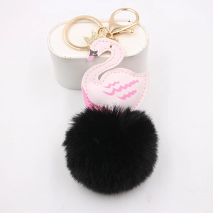 Détail d'un porte-clés cygne en cuir rose avec un gros pompon noir en peluche douce
