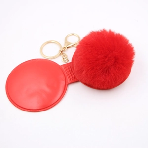 Close-up of red faux fur pompom keychain with golden metal ring and lobster clasp detail
