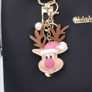 Christmas reindeer leather keychain with red hat and pearl charm on black bag