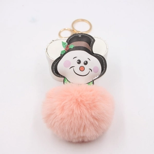 Close-up of pink pom pom snowman keychain with golden metal ring and red berry detail