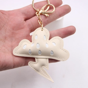 Détail du porte-clés nuage et éclair en cuir crème avec fermoir mousqueton doré