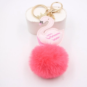 Porte-clés cygne rose avec couronne dorée et pompon en peluche sur support blanc