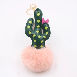 Detailed close-up of cactus plush keychain with green leather and pink pompom on gold ring