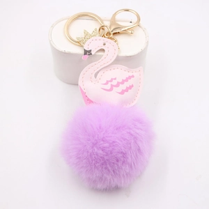 Détail du pendentif cygne en cuir rose avec pompon en fourrure violette et doré
