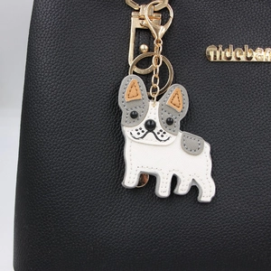 Cute French Bulldog leather keychain charm in white and grey on a black leather bag