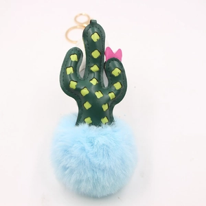 Close-up of a cactus leather keychain with a large light blue fluffy faux fur pompom ball