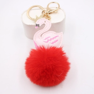 Détail du pendentif cygne rose avec pompon en peluche rouge et porte-clés doré élégant