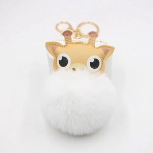 Détail du porte-clés pompon blanc en fausse fourrure avec fermoir doré et motif girafe