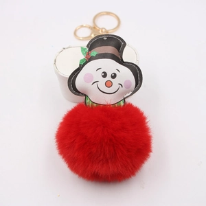Detail of plush red pompom keychain with snowman head and golden metal clasp